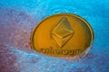 Golden Ethereum coin, online digital currency frozen in the blue ice. Concept of block chain, market crash. Frozen crypto money,