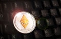 Golden Ethereum ETH coin over black keyboard