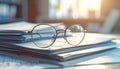 Golden Eyeglasses on Stack of Documents in a Bright Office Setting Royalty Free Stock Photo