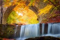 Golden Fall Autumn landscape - river waterfall in colorful autumn forest park with yellow red leaves with old bridge Royalty Free Stock Photo