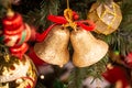 Golden festive Christmas bells and holiday balls on a Christmas tree close-up. Royalty Free Stock Photo