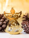 Golden figure of Christmas angel, pine cones, sparkling background, festive, greeting card template