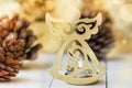 Golden figure of Christmas angel, pine cones, sparkling luminous background, festive, greeting card template