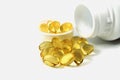 Golden fish oil capsules in glass bowl on white background, panoramic shot Royalty Free Stock Photo