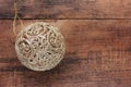 Golden fishnet Christmas ball on wooden background. Top view of luxury Christmas ornament on wood table.