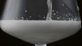 Golden fizzy beverage bubbling pouring into goblet in super slow motion close up