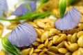 Golden flax seeds with blue flower petals