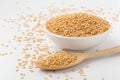 Golden flaxseed in white bowl with wooden spoon