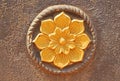 Golden flower in a brown circle. India