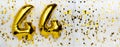 Golden foil balloon number, figure forty-four on white with confetti background. 44th birthday card. Anniversary concept Royalty Free Stock Photo