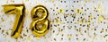 Golden foil balloon number, figure seventy-eight on white with confetti background. 78th birthday card. Anniversary