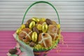 Golden foil chocolate eggs with cute Easter chick decorations and hot cross buns