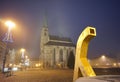 Golden fountain with a cathedral tower in the background in foggy early morning Royalty Free Stock Photo