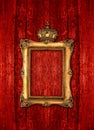 Golden frame with crown over red wooden background Royalty Free Stock Photo