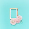 Golden frame with pink ranunculus flowers on light blue background. Holiday, greetings, love, romantic concept. Flat lay, copy