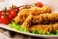 Golden fried chicken strips in breading with salad and tomatoes Royalty Free Stock Photo