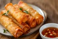 Golden fried spring roll served with a side of sauce