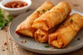 Golden fried spring roll served with a side of sauce