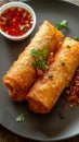 Golden fried spring roll served with a side of sauce