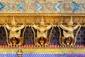 Golden garuda and naga statue, decoration on a wall of The Emerald Buddha temple, Wat Phra Kaew, Grand Palace, Bangkok, Thailand Royalty Free Stock Photo