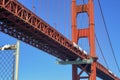 Golden gate bridge from below with visible red girders and iron steel beams with suspension design and small fence Royalty Free Stock Photo