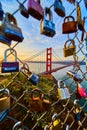 Golden Gate Bridge in California through hole in chain link fence covered in locks Royalty Free Stock Photo