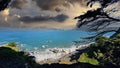 The Golden Gate Bridge at Mile Rock Beach with blue ocean water, waves, rocks and lush green trees on Lands End Trail Royalty Free Stock Photo