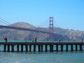 Golden Gate Bridge and people walking along a jetty