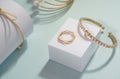 Golden gemstones bracelets set with golden ring on white cube display