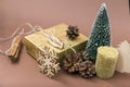 Golden gift box, cones, small Christmas tree, Golden candle, snowflake, cinnamon sticks on brown background, merry Christmas Royalty Free Stock Photo