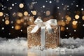 Golden gift box on festive dark black bokeh background with decorative winter snow