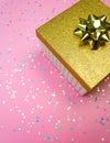 Golden gift box and rainbow holographic stars confetti on led neon pink background. Trendy magenta holiday vertical concept Royalty Free Stock Photo