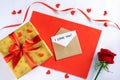 Golden gift box with red ribbon on fabric, envelope, card with iscription i love you and little hearts Royalty Free Stock Photo