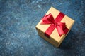 Golden gift box with shiny red satin bow Royalty Free Stock Photo