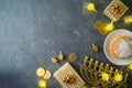 Golden gift box, traditional donuts and menorah on dark background. Hanukkah greeting card design