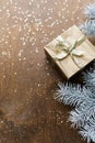 a golden gift box on a wooden table with gold spangles in the shape of stars, among the fir branches