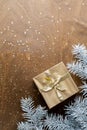 a golden gift box on a wooden table with gold spangles in the shape of stars, among the fir branches