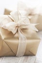 Golden gift boxes with beautiful ribbon and bow on a bright shin Royalty Free Stock Photo