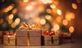 Golden gift boxes with ribbon bow tag over blurred bokeh background with lights. Birthday or Christmas decor. Blinking Royalty Free Stock Photo