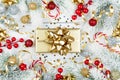 Golden gift or present box, snowy fir tree and christmas decorations on white table top view. Flat lay style. Royalty Free Stock Photo