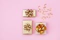 Golden gift or present boxes and star confetti on pink background top view. Flat lay for birthday, christmas or wedding. Royalty Free Stock Photo