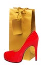 Golden gift shopping bag and red high heeled woman shoe isolated Royalty Free Stock Photo