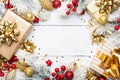 Golden gifts or presents boxes, snowy fir tree and christmas decorations on white wooden table top view. Flat lay.