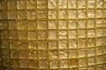 Golden glass checkered texture or abstract geometric mesh pattern or background. Golden-colored glass or mosaic smalt