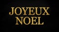 Golden glitter with the french words for merry christmas - joyeux noel on black chalkboard background