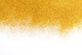 Golden glitter sand texture on white, abstract background.