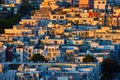 Golden glow on side by side residential buildings going up hillside in California at sunset