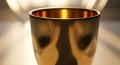 A golden goblet with a smooth, polished surface reflects warm light, creating sof Royalty Free Stock Photo