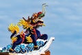 Golden gragon statue on red pillar in the shrine with blue sky.