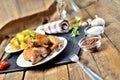 Golden grilled chicken legs on a plate and roasted potatoes, rosemary, jug with oil, oregano, salt, pepper and garlic on Royalty Free Stock Photo